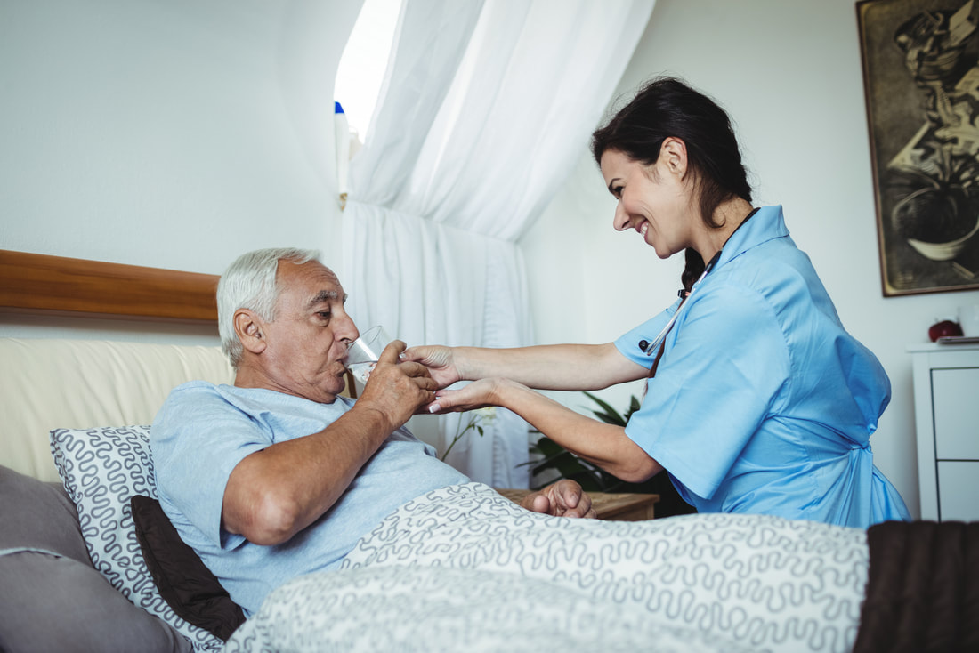 a nurse helping an elderly man in bed